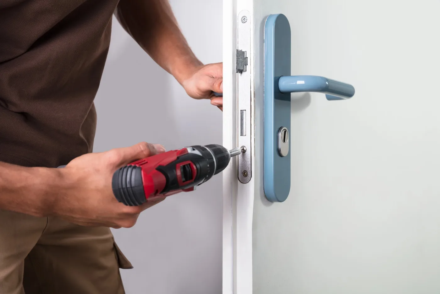 Serrurier indépendant réparant une serrure encastrée sur une porte aux Mureaux (78130)